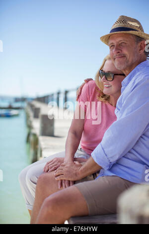 Paar sitzt am Rand des hölzernen Dock zusammen Stockfoto