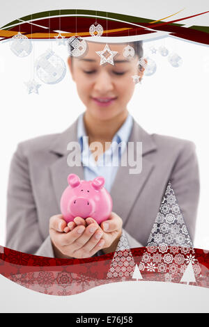 Zusammengesetztes Bild des Porträts von eine junge Geschäftsfrau hält ein Sparschwein Stockfoto