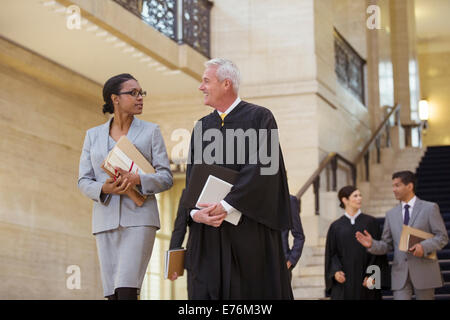 Richter und Anwalt zu Fuß durch Gerichtsgebäude zusammen Stockfoto