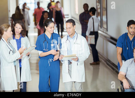 Arzt und Krankenschwester lesen medizinischen Diagramm im Krankenhaus-Flur