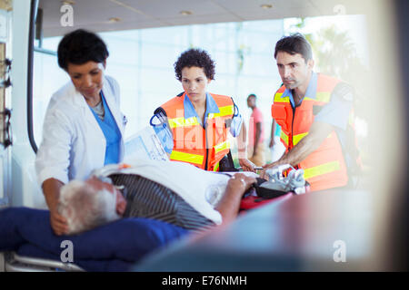 Sanitäter und Krankenschwester untersuchen Patienten in Ambulanz Stockfoto