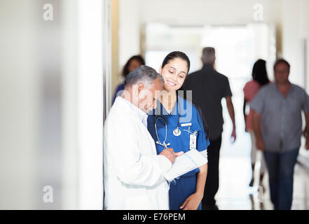 Arzt und Krankenschwester lesen medizinischen Diagramm im Krankenhaus-Flur Stockfoto