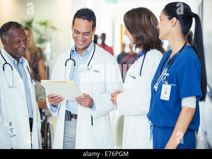 Ärzte und Krankenschwester im Krankenhaus Flur im Gespräch Stockfoto