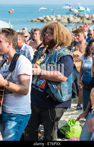 Lyme Regis, Dorset, England. Einige Gitarristen auf die Gitarren auf den Beach-Event spielt zusammen mit Rockin ' auf der ganzen Welt Stockfoto