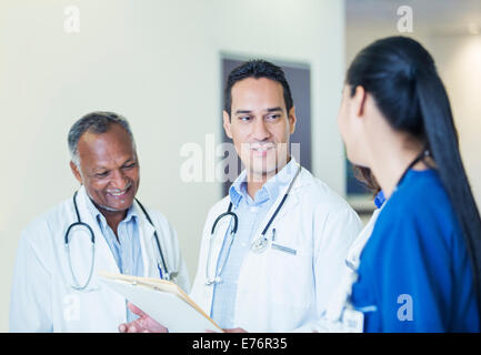 Ärzte und Krankenschwester im Krankenhaus Flur im Gespräch Stockfoto