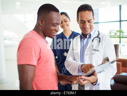 Arzt und Patient lesen medizinischen Diagramm im Krankenhaus Stockfoto