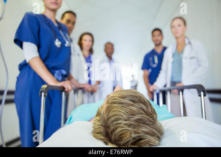 Ärzte und Krankenschwestern, die Patienten im Krankenhaus Flur Machenschaften Stockfoto