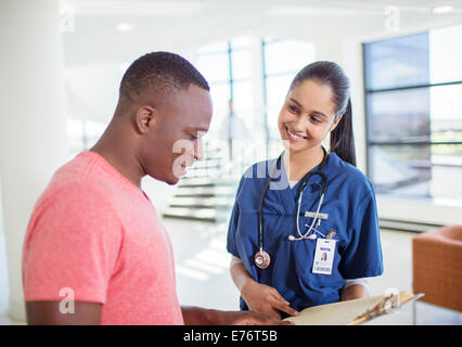 Krankenschwester und Patient lesen medizinischen Diagramm im Krankenhaus Stockfoto