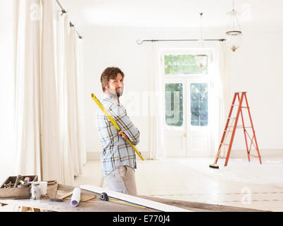 Mann mit Blick auf Wohnraum in der Nähe von Baumaterialien Stockfoto