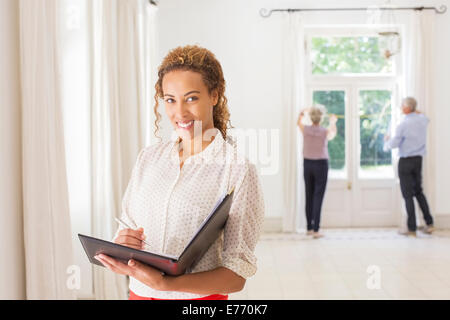 Frau mit Bindemittel im Wohnraum Stockfoto