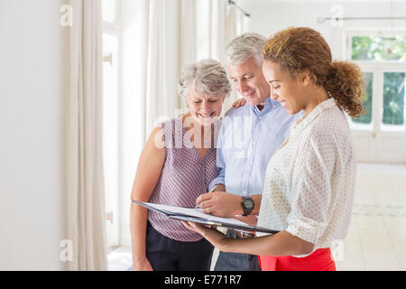 Älteres Paar und Frau Signieren von Dokumenten Stockfoto