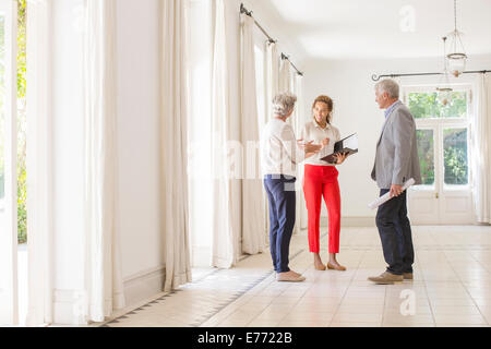 Älteres Ehepaar im Gespräch mit Frau im Wohnraum Stockfoto