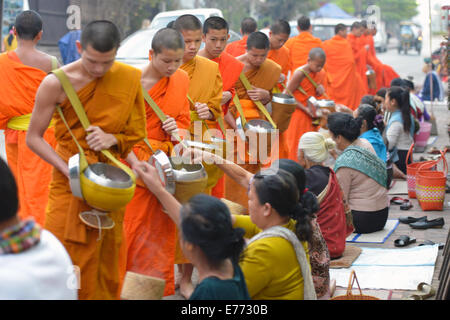 Luang Prabang, Laos - 2. März 2014: Mönche gehen um Almosen und Angebote in Luang Prabang, Laos zu sammeln. Stockfoto