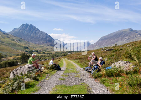 Wanderer mit einer Unterbrechung durch einen Anschluss in Ogwen Valley ruht mit Blick auf Mount Tryfan in Snowdonia Nationalpark Berge. Ogwen Valley North Wales UK Stockfoto