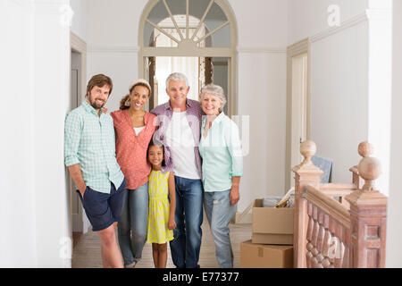 Familie lächelnd zusammen in Wohnraum Stockfoto