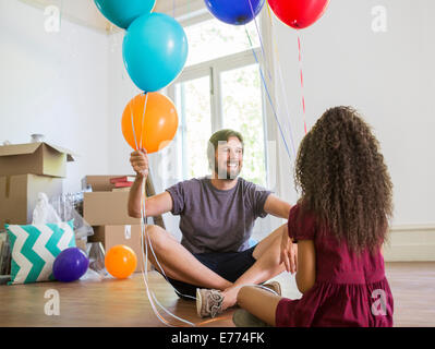 Vater und Tochter spielen mit Luftballons Stockfoto