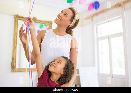 Mutter und Tochter Ballons zusammenhalten Stockfoto