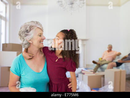 Großmutter und Enkelin umarmt im Wohnraum Stockfoto