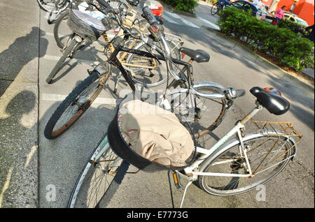 Caorle, Veneto, Italien. Mai 2014 abgestellt Fahrräder entlang der italienischen Straße in Caorle Resort. Stockfoto