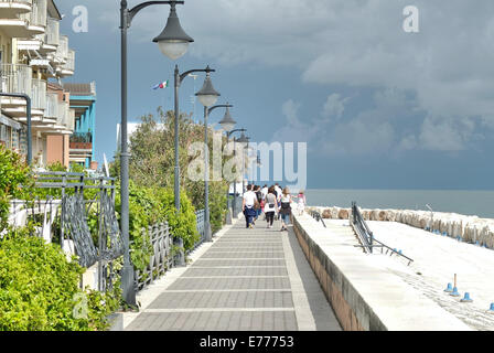 Caorle, Veneto, Italien. Mai 2014 Menschen Spaziergänge entlang der Promenade an der Adria-Küste im Ferienort Caorle Stockfoto