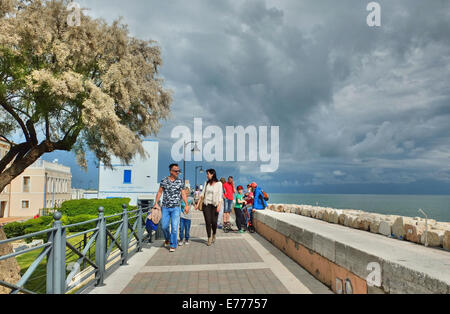 Caorle, Veneto, Italien. Mai 2014 Menschen Spaziergänge entlang der Promenade an der Adria-Küste im Ferienort Caorle Stockfoto