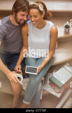 Paar, lachen zusammen auf Treppe Stockfoto