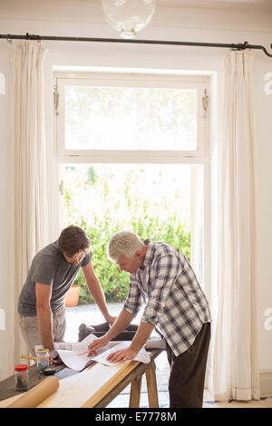 Vater und Sohn, die Konstruktionsplänen durchsehen Stockfoto