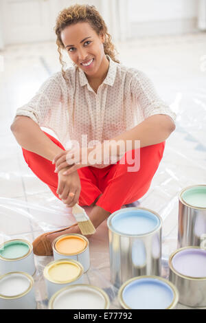 Frau mit Blick auf Raum mit Farbe Dosen in der Nähe von Stockfoto