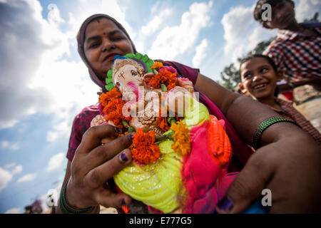 Neu-Delhi, Indien. 8. Sep, 2014. Indische Anhänger vorzubereiten, ein Idol der elefantenköpfige Hindugott Ganesha an einem Fluss am letzten Tag des Ganesh Charturthi Festivals in New Delhi, der Hauptstadt von Indien, 8. September 2014 einzutauchen. Hinduistische Gläubigen gefeiert Ganesh Chaturthi zu Ehren des Gottes Ganesha, der elefantenköpfige, Remover von Hindernissen und dem Gott der Anfänge und der Weisheit, während das elf Tage lang Festival, das mit dem Eintauchen der Idole in verschiedenen Gewässern schließt. Bildnachweis: Zheng Huansong/Xinhua/Alamy Live-Nachrichten Stockfoto