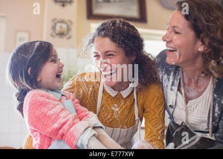 Drei Generationen von Frauen spielen in der Küche Stockfoto