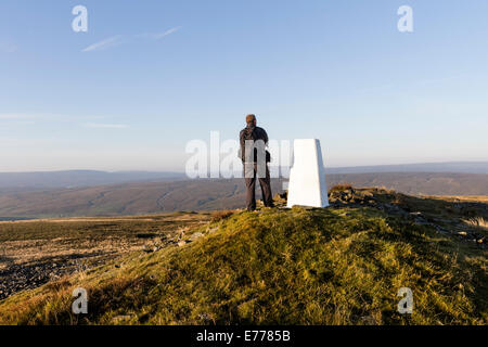 Walker am Trig Punkt großen steinigen Hügel und Ansicht Süd, Coldberry, Teesdale, County Durham UK Stockfoto