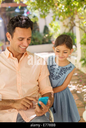 Vater und Tochter Blick auf Handy Stockfoto