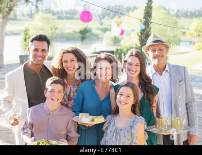 Familie lächelnd zusammen im freien Stockfoto