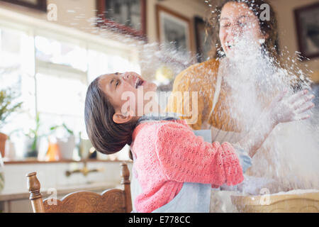 Mutter und Tochter spielen mit Mehl in der Küche Stockfoto