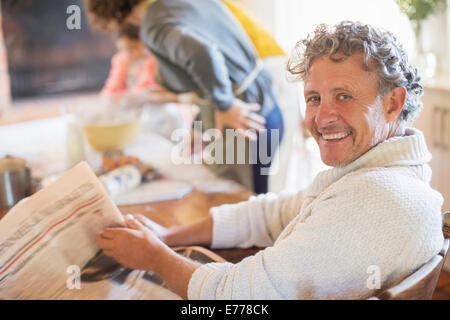 Ältere Mann liest Zeitung in Küche Stockfoto