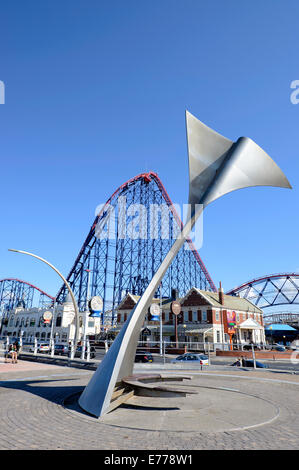 Whale Tail Skulptur auf der Promenade in Blackpool mit dem "Big One"-Achterbahn hinter Stockfoto