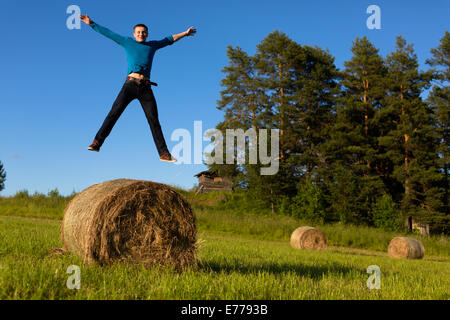 Mann springt in einem Feld Stockfoto