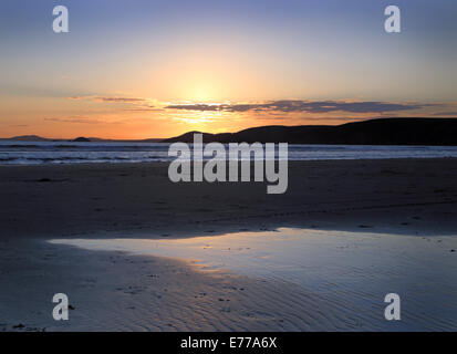 Newgale Strand in Pembrokeshire bei Sonnenuntergang mit der untergehenden Sonne, reflektiert schönen hellen, glatten weiten Sand Stockfoto