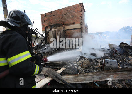 Sao Paulo, Brasilien. 8. Sep, 2014. Ein Feuerwehrmann arbeitet in den Trümmern einer verbrannten Favela im Süden von Sao Paulo, Brasilien, am 8. September 2014. Ein Feuer, das hier am Sonntagabend begann obdachlos 600 Familien. Noch wurden keine Verletzten gemeldet. Bildnachweis: Rahel Patras/Xinhua/Alamy Live-Nachrichten Stockfoto
