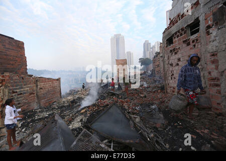 Sao Paulo, Brasilien. 8. Sep, 2014. Anwohner sammeln Habseligkeiten auf den Trümmern einer verbrannten Favela im Süden von Sao Paulo, Brasilien, am 8. September 2014. Ein Feuer, das hier am Sonntagabend begann obdachlos 600 Familien. Noch wurden keine Verletzten gemeldet. Bildnachweis: Rahel Patras/Xinhua/Alamy Live-Nachrichten Stockfoto