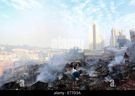 Sao Paulo, Brasilien. 8. Sep, 2014. Anwohner suchen hab und gut auf den Trümmern einer verbrannten Favela im Süden von Sao Paulo, Brasilien, am 8. September 2014. Ein Feuer, das hier am Sonntagabend begann obdachlos 600 Familien. Noch wurden keine Verletzten gemeldet. Bildnachweis: Rahel Patras/Xinhua/Alamy Live-Nachrichten Stockfoto