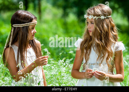 Porträt von zwei Mädchen in Blumenwiese stehend hautnah. Stockfoto