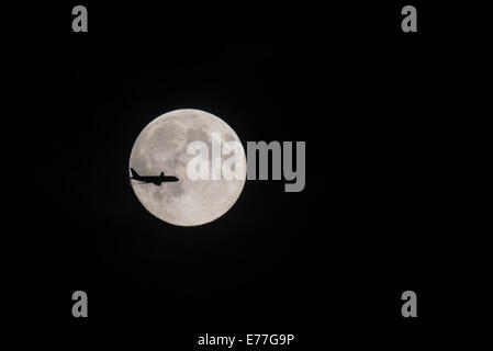 London, UK. 8. Sep, 2014. Ein Passagierflugzeug nähert sich der Flughafen Heathrow ist Silhouette gegen die dritte und letzte volle Supermoon 2014 Kredite: Piero Cruciatti/Alamy Live News Stockfoto