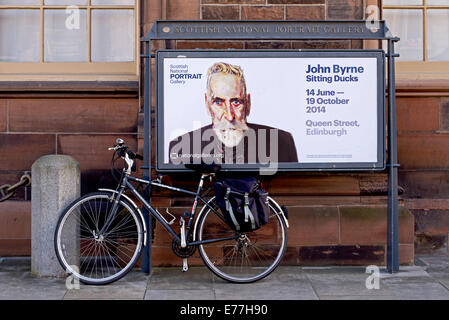 Ein Fahrrad befestigt auf eine Anzeige für ein John Byrne-Ausstellung in der Scottish National Portrait Gallery in Edinburgh, Scotland, UK Stockfoto