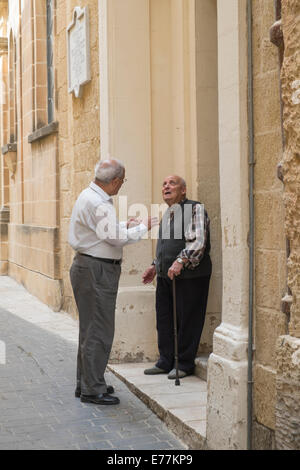 Zwei ältere Männer im Chat in einer Seitenstraße von Victoria, Gozo, der Hauptstadt Stockfoto