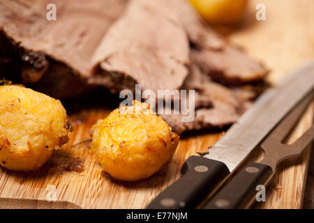 Makro des Bratkartoffeln und Lamm auf dem Schneidebrett Stockfoto