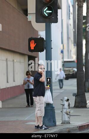 Piers Morgan 3/4 Länge tragen shorts wartet, überqueren Sie die Straße mit seinem Imbiss in einer Plastiktüte, während der Einnahme eines Anrufs auf seinem Handy mit Telefon: Piers Morgan Where: Los Angeles, California, Vereinigte Staaten von Amerika bei: 6. März 2014 Stockfoto