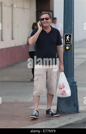 Piers Morgan 3/4 Länge tragen shorts wartet, überqueren Sie die Straße mit seinem Imbiss in einer Plastiktüte, während der Einnahme eines Anrufs auf seinem Handy mit Telefon: Piers Morgan Where: Los Angeles, California, Vereinigte Staaten von Amerika bei: 6. März 2014 Stockfoto