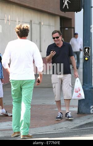 Piers Morgan 3/4 Länge tragen shorts wartet, überqueren Sie die Straße mit seinem Imbiss in einer Plastiktüte, während der Einnahme eines Anrufs auf seinem Handy mit Telefon: Piers Morgan Where: Los Angeles, California, Vereinigte Staaten von Amerika bei: 6. März 2014 Stockfoto