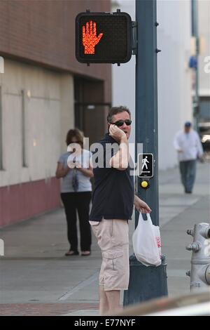 Piers Morgan 3/4 Länge tragen shorts wartet, überqueren Sie die Straße mit seinem Imbiss in einer Plastiktüte, während der Einnahme eines Anrufs auf seinem Handy mit Telefon: Piers Morgan Where: Los Angeles, California, Vereinigte Staaten von Amerika bei: 6. März 2014 Stockfoto